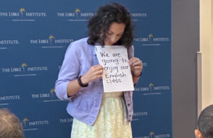 Teacher holding english phrase "We are going to enjoy our english class" for students to read